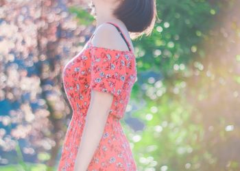 woman wearing dress and sunglasses standing near trees