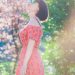 woman wearing dress and sunglasses standing near trees