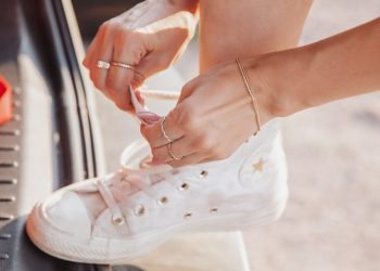 person wearing white low top sneakers