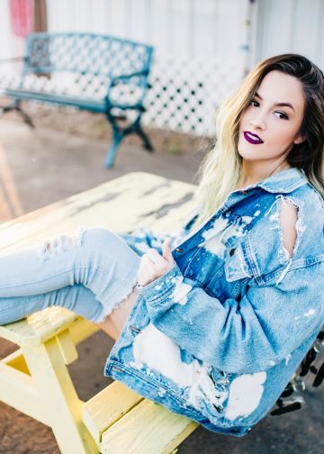 smiling woman sitting on yellow picnic table during daytime