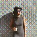 woman standing near the wall while holding beer bottle