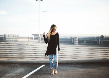 woman standing on gray concrete pavement