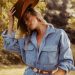a woman in a blue shirt dress and a cowboy hat