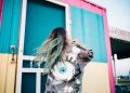 woman wearing grey denim jacket standing beside intermodal container